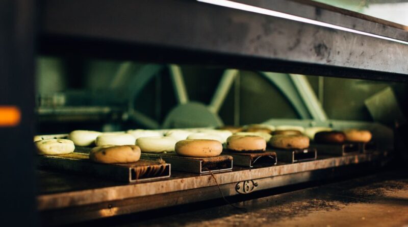 Multiple bagels baking in an industrial oven, showcasing a warm bakery ambiance. - Photo by Rachel Claire on Pexels