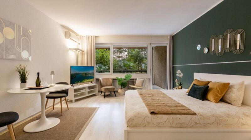 Stylish studio apartment featuring modern decor, green accent wall, and large windows. - Photo by Image Hunter on Pexels