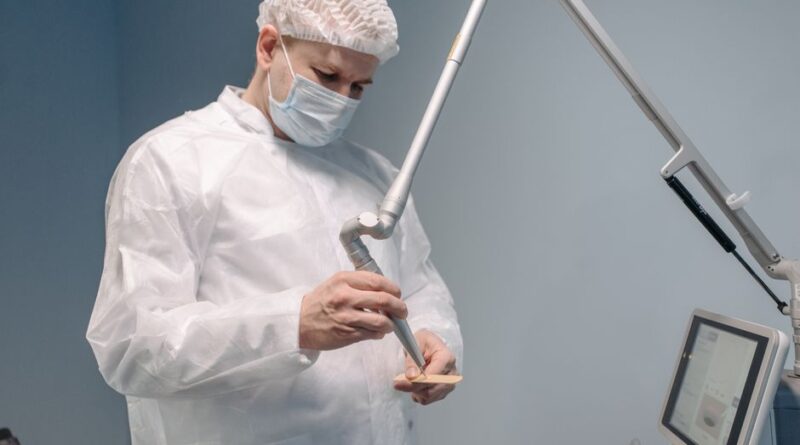 Doctor wearing protective gear using a laser machine in a clinic setting. - Photo by Pavel Danilyuk on Pexels